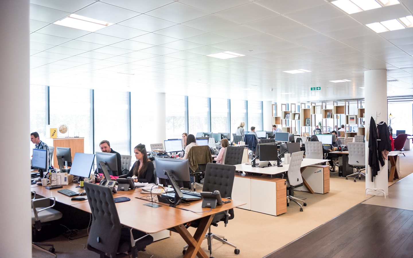 An open-plan corporate office floor with staff working at their desks